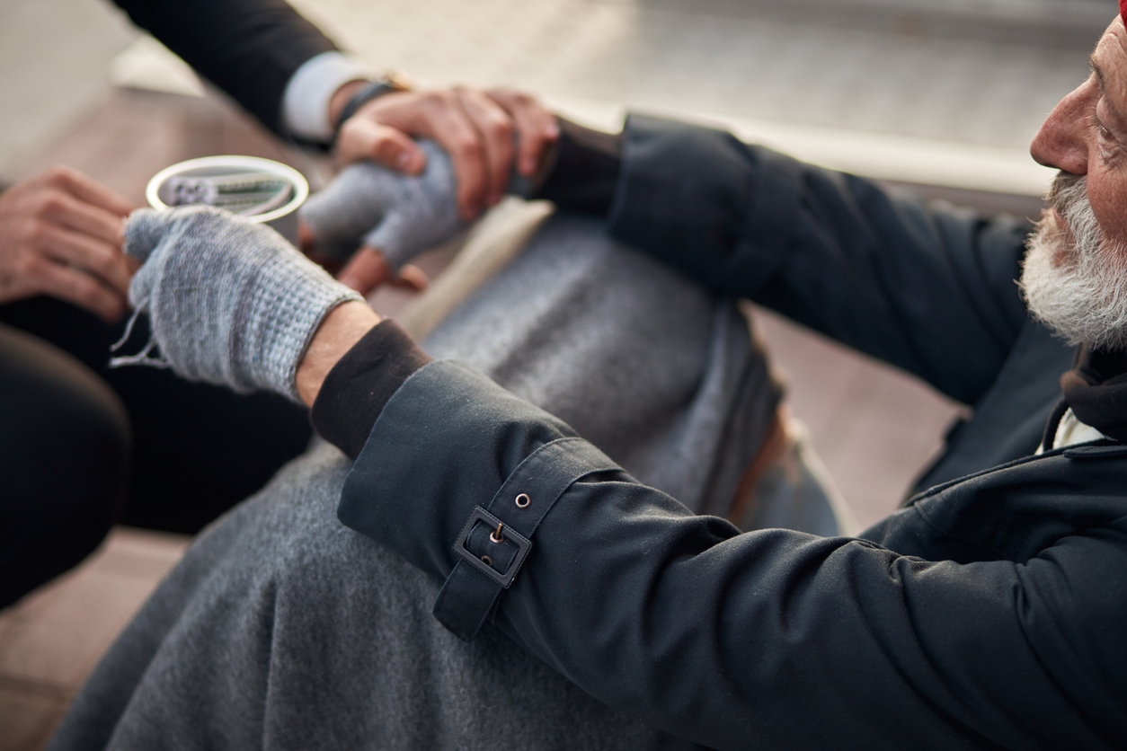 Homeless man sitting on walking street in need of help